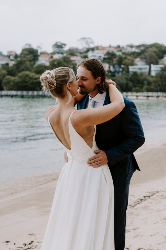 Bride-and-groom-Couple-kissing-on-beach-at-wedding